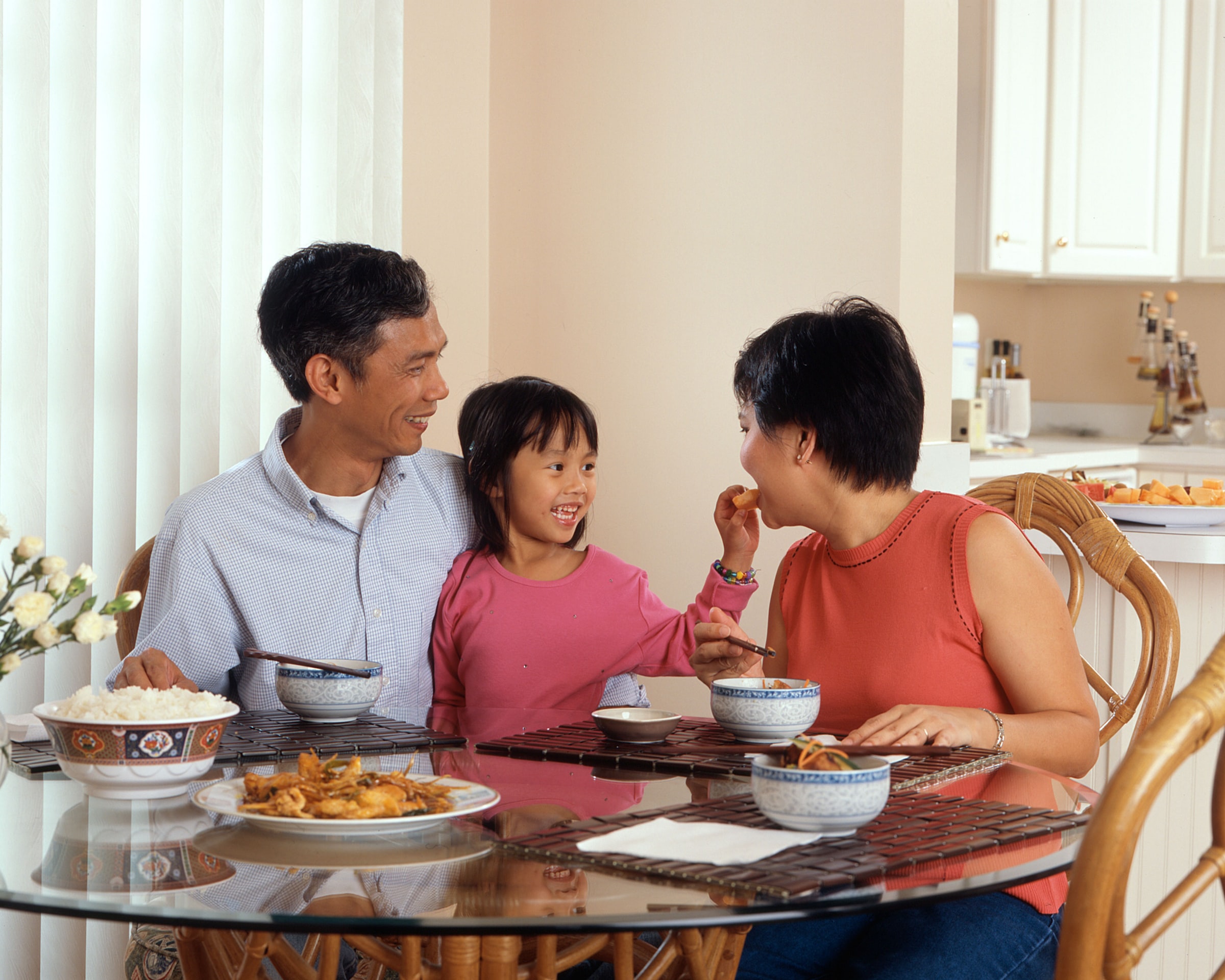 Photo of a family sitting at a table eating a meal.