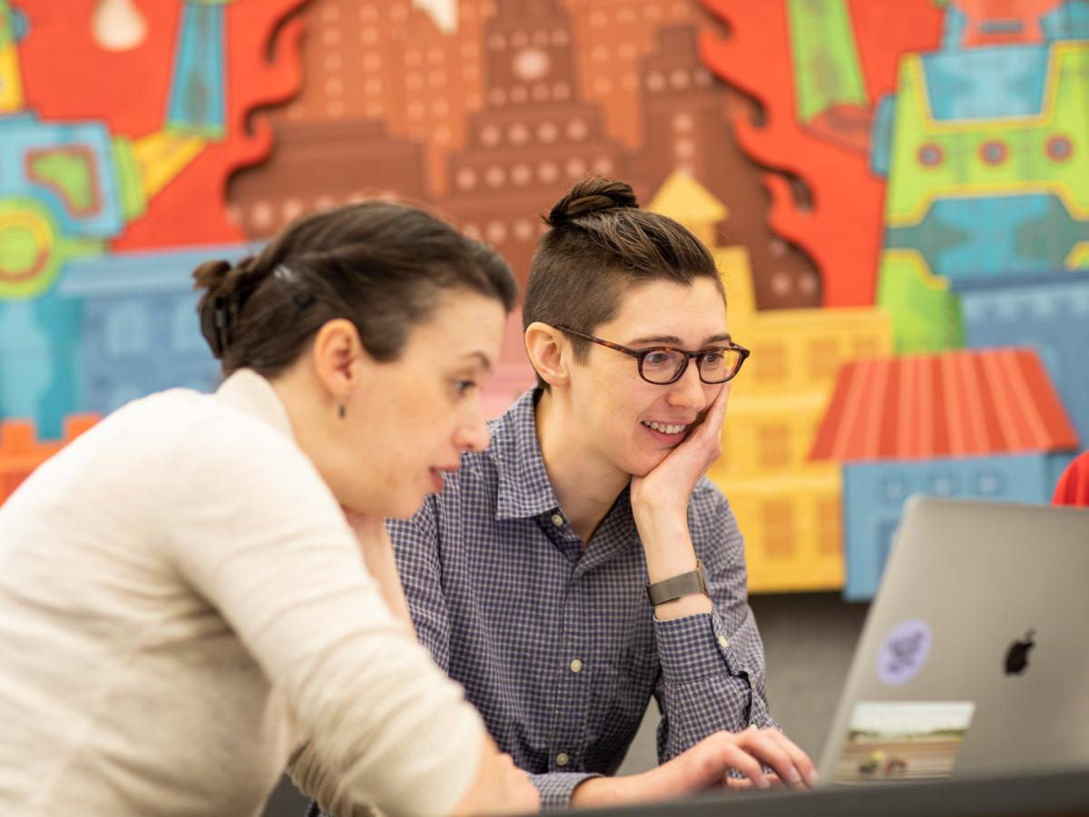 Two people looking at a laptop screen together