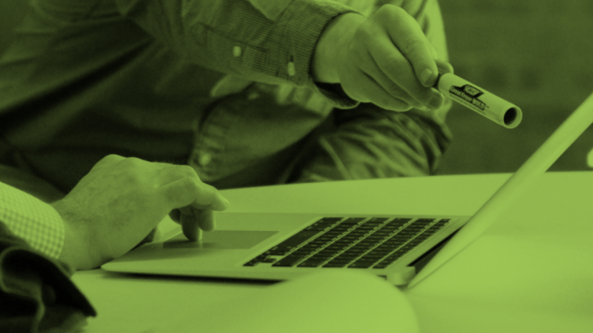 Photo of person arm pointing with marker at laptop screen