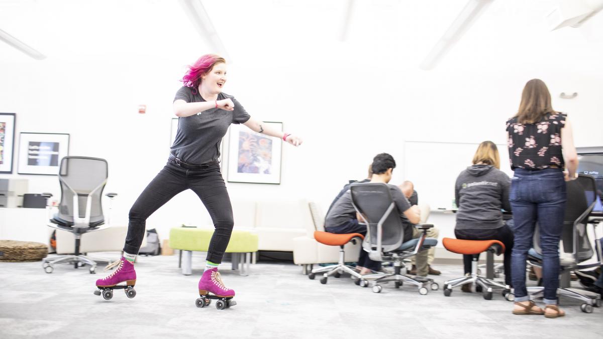 Photo of a person roller skating through Palantir's offices at a team retreat
