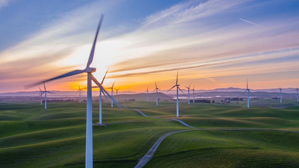Photo of wind power turbines with clouds in the background