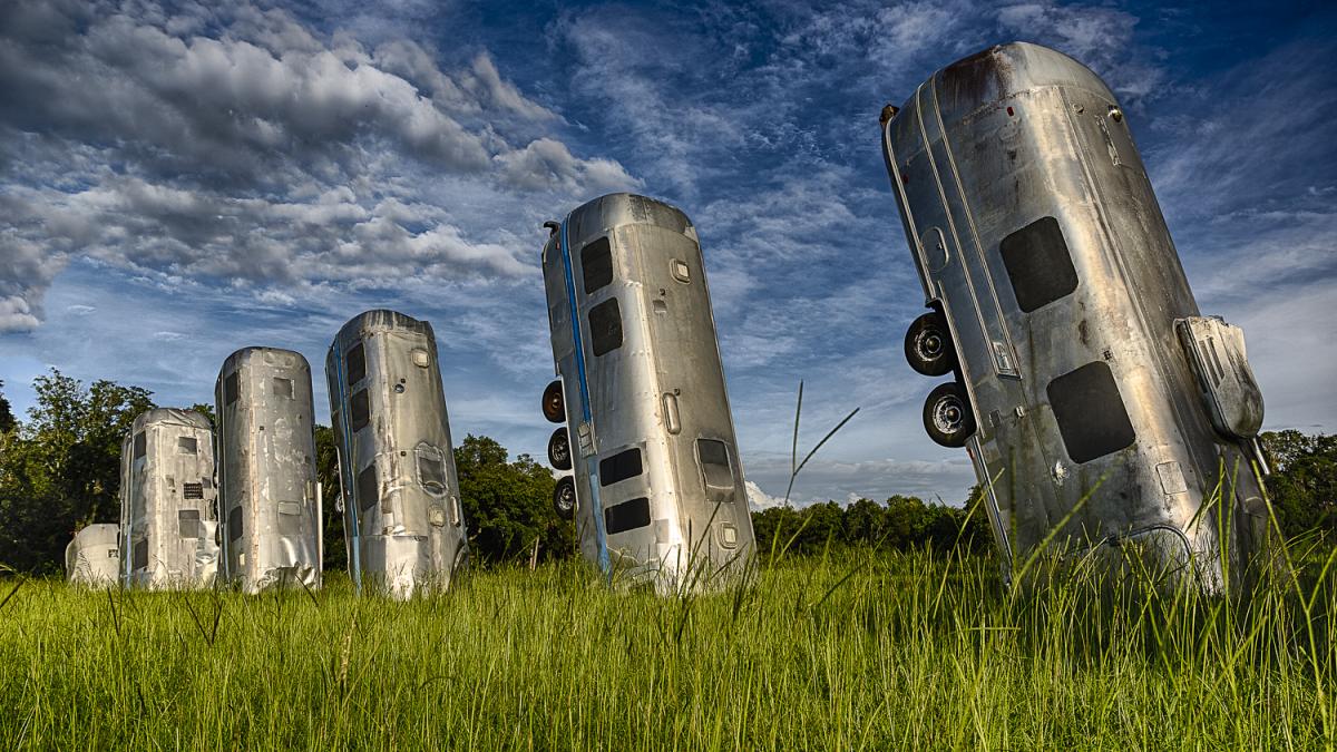 Photo of several old Airstream trailers buried end-up in a field