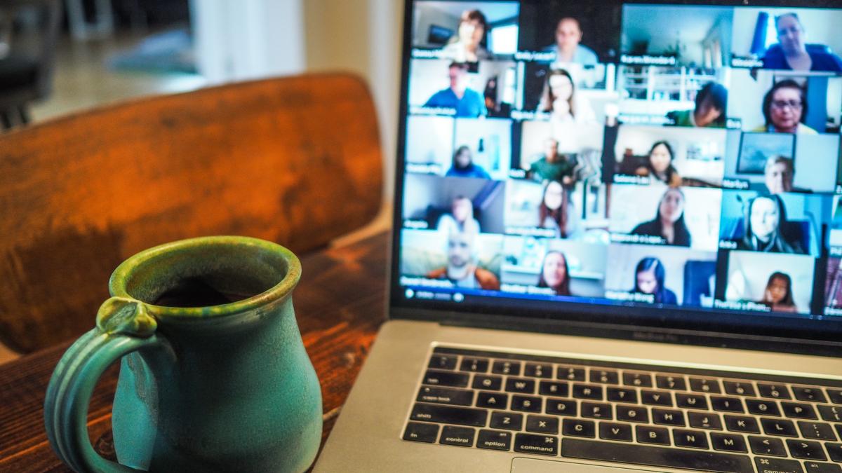 Online student chat with coffee mug next to laptop screen