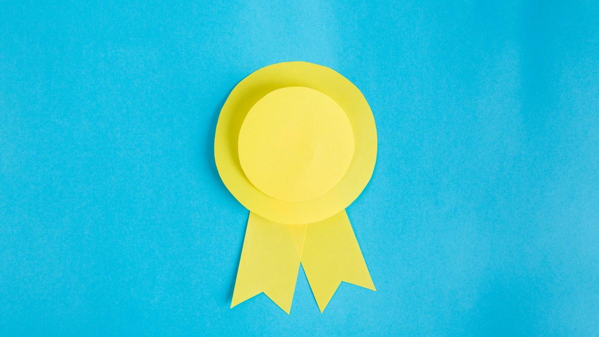 Image of a paper cut yellow badge on a blue background
