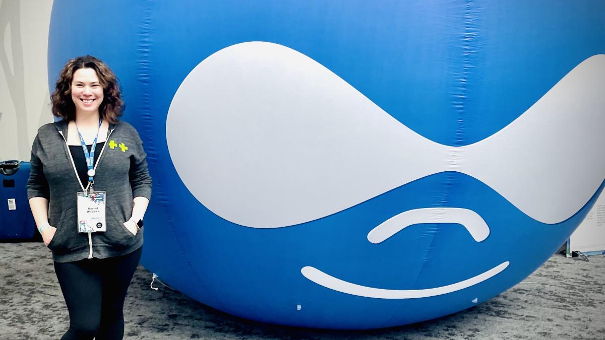 Rachel in front of a large inflatable Drupal logo balloon
