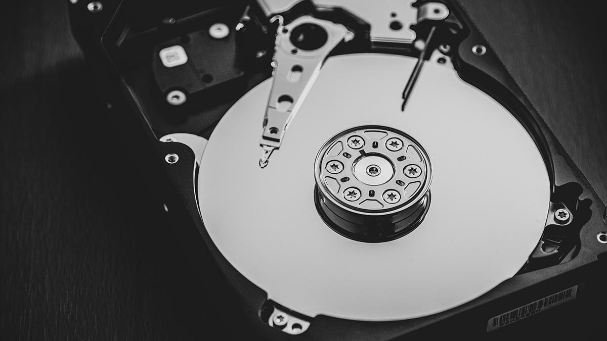 A close-up view of the inside of a hard disk drive, revealing the magnetic platters used for data storage and the mechanical arm with the read/write head.
