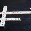 Photo of Scrabble tiles on a dark wood surface with the words OCCUPATION, APPLICATION, RESUME, and HIRING