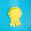 Image of a paper cut yellow badge on a blue background
