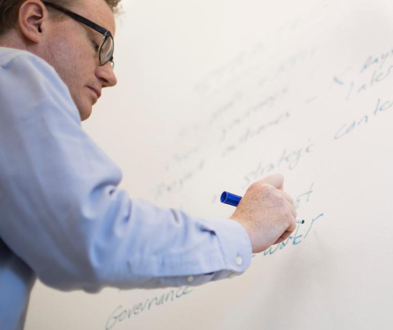 Man writing on white board